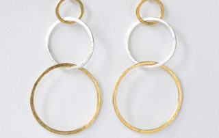 Christine Rettinger schmiedet einzelne Ringe in unterschiedlichen Größen aus Sterlingsilber und fügt sie zu Ohrsteckern zusammen. Einige Modelle bekommen durch feinvergoldete Ringe einen ganz besonderen Touch.