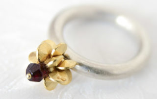 Aus der Kollektion "Gold- und Silberblümchen" geschmiedeter Ring mit Sterlingsilber-Blümchen, feinvergoldet, Granat..